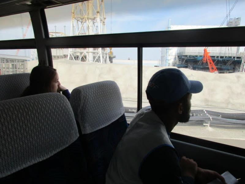 Students inside a bus observe the wreckage at the Fukushima Daiichi Nuclear Power Plant.